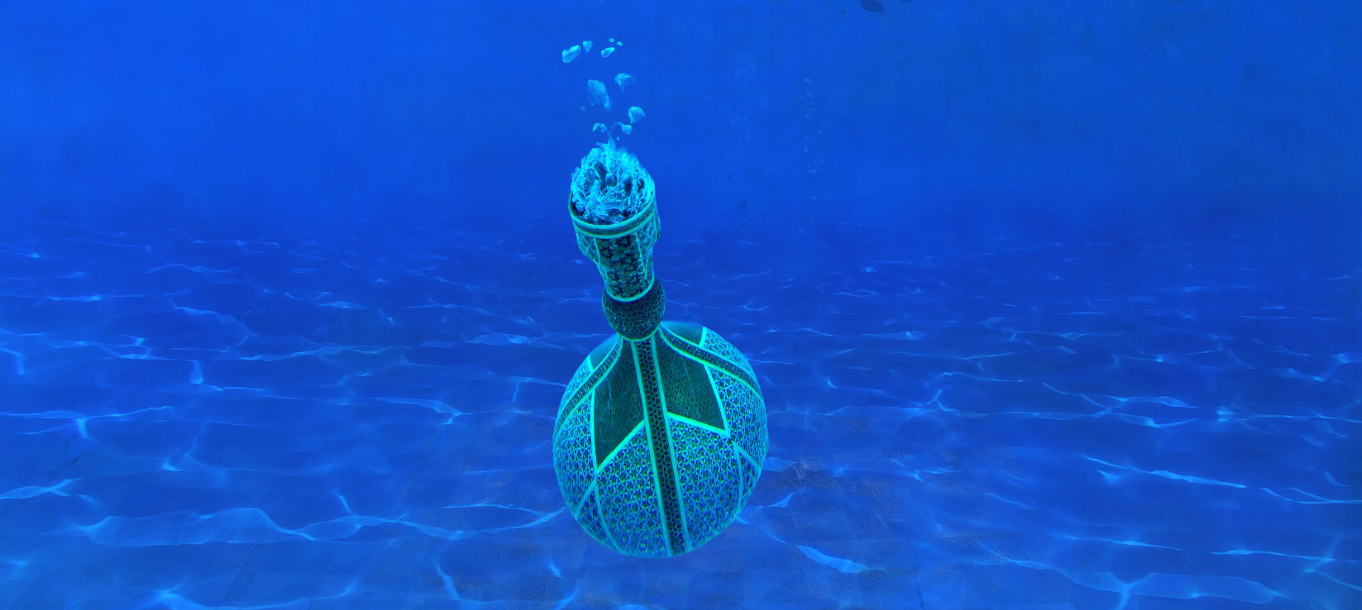 A photographic image featuring a deep blue ultramine ocean which seems to go on forever. It recedes deeply with faint images in the background. In the foreground a  beautiful bottle is clear and close to the camera, it levitates as it sinks to the bottom.