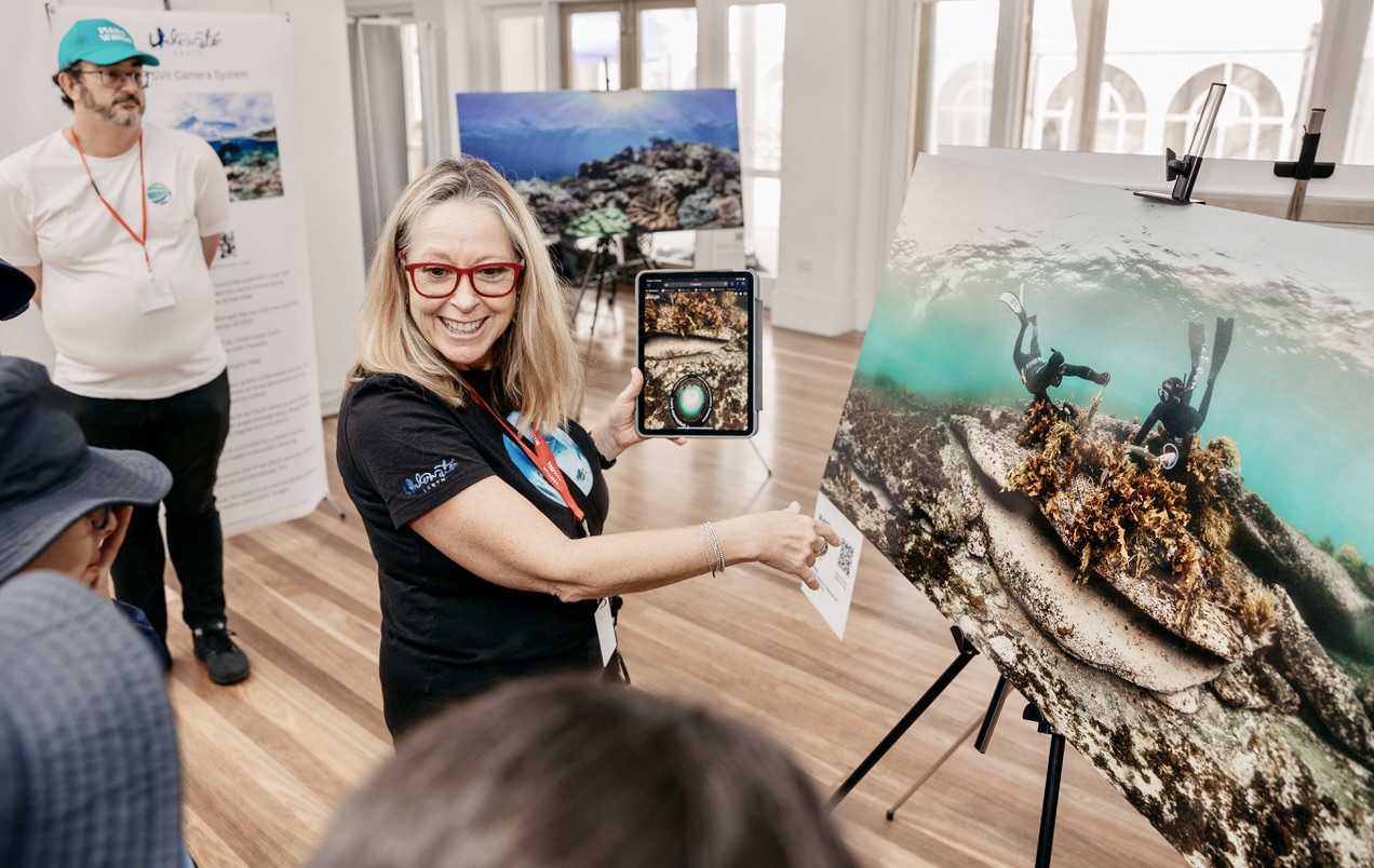 Teacher teaching about marine species in high tide room with ipad