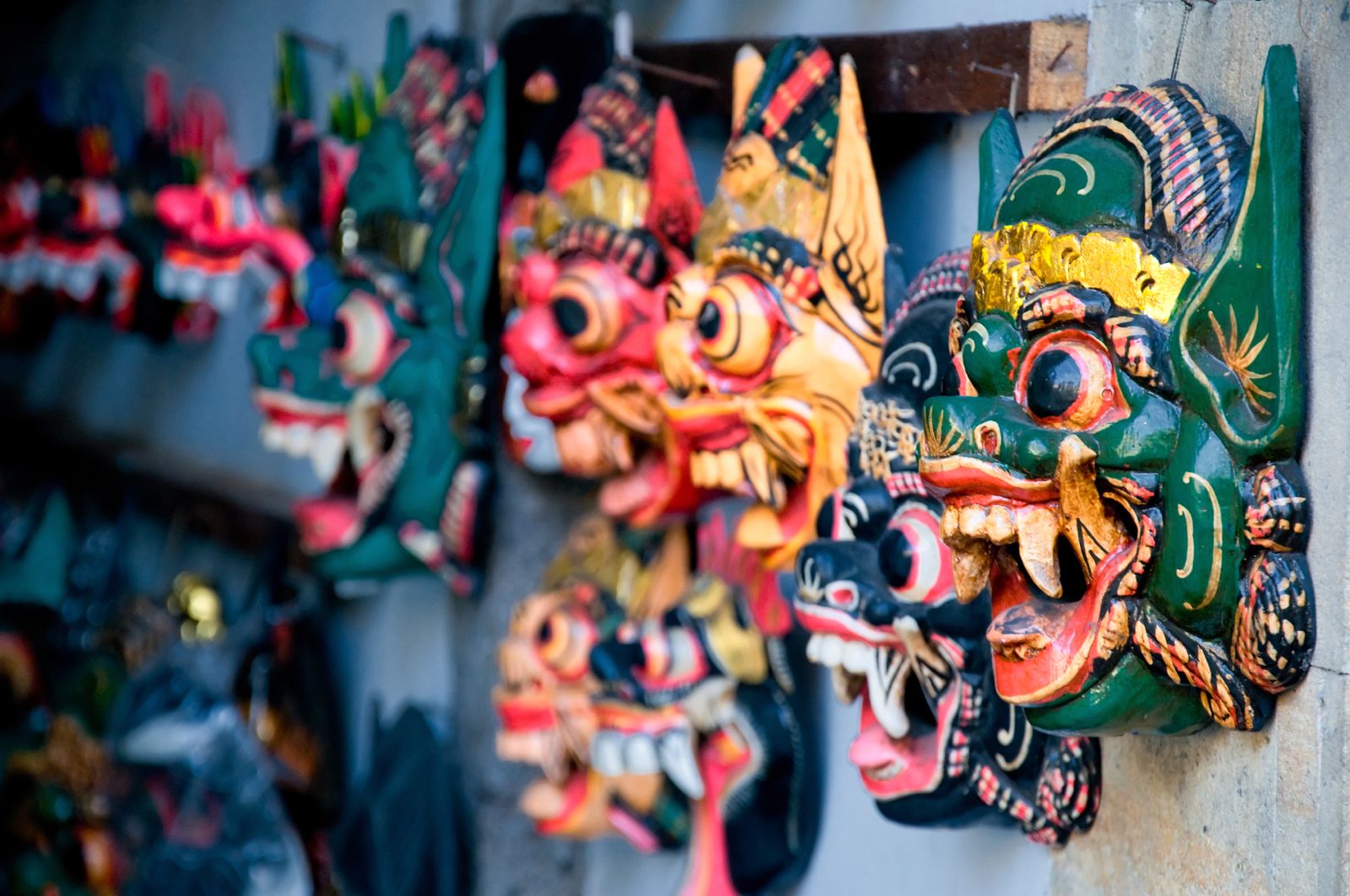 Indonesian wood work masks hung on a wall