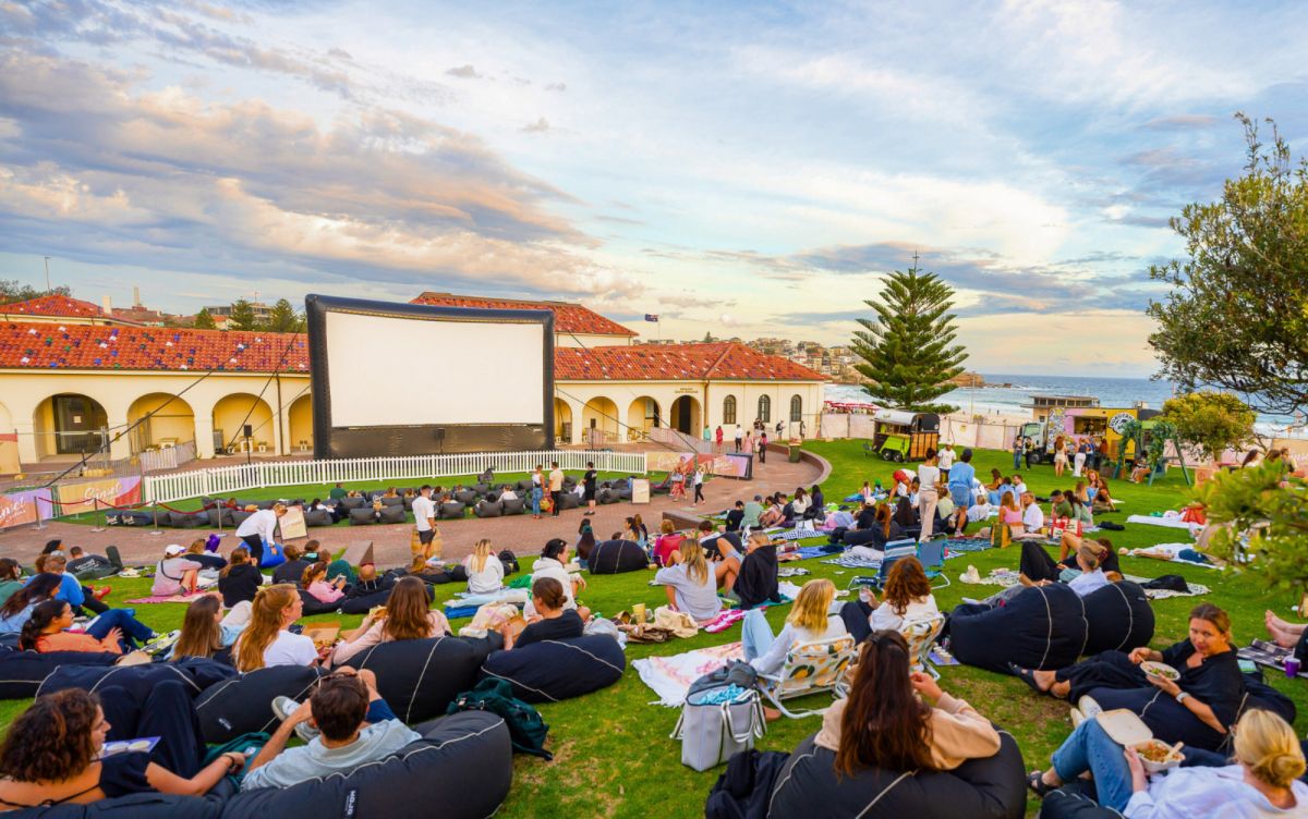 Outdoor cinema people laying on blanket watching movies at twilight