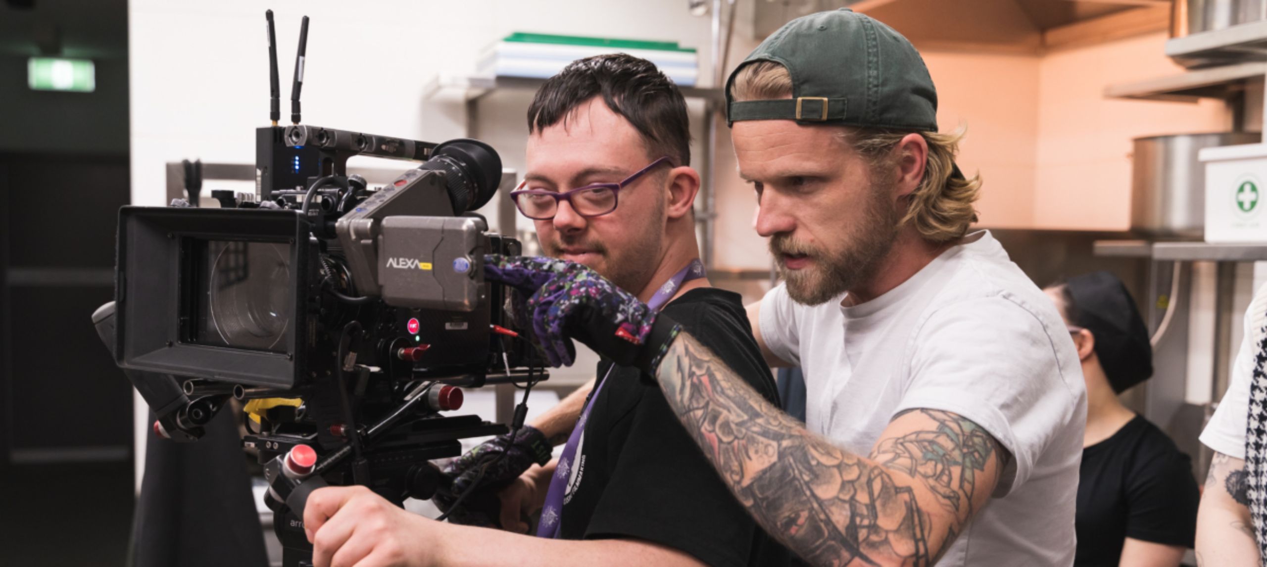 Camera operator showing a young man how to use the camera