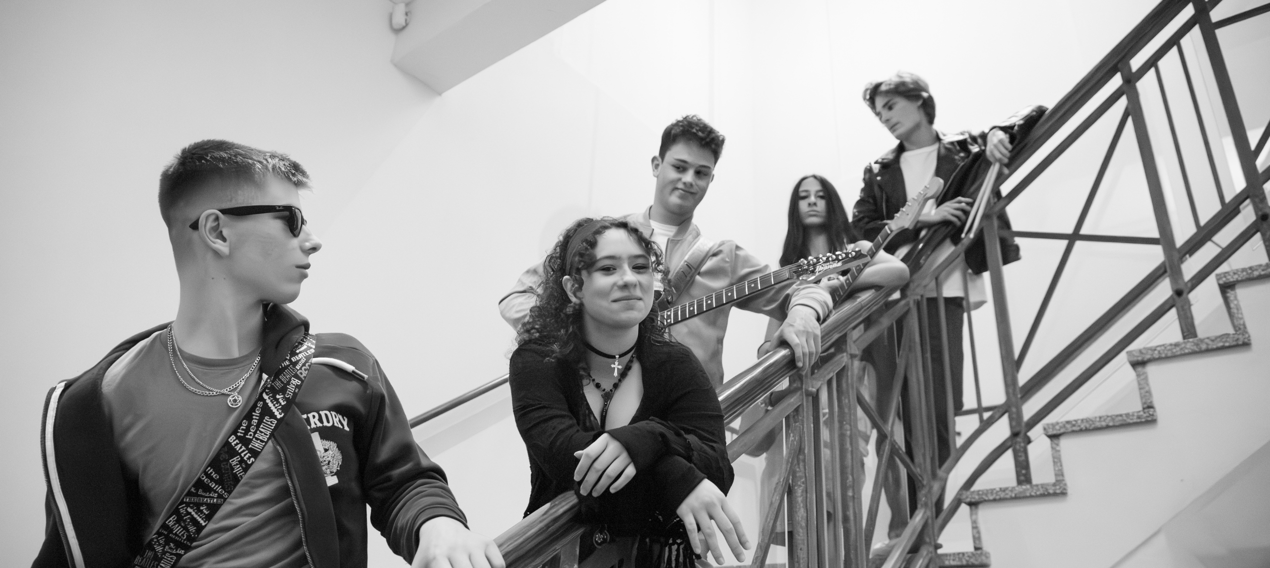 Cool band looking in different directions standing on staircase