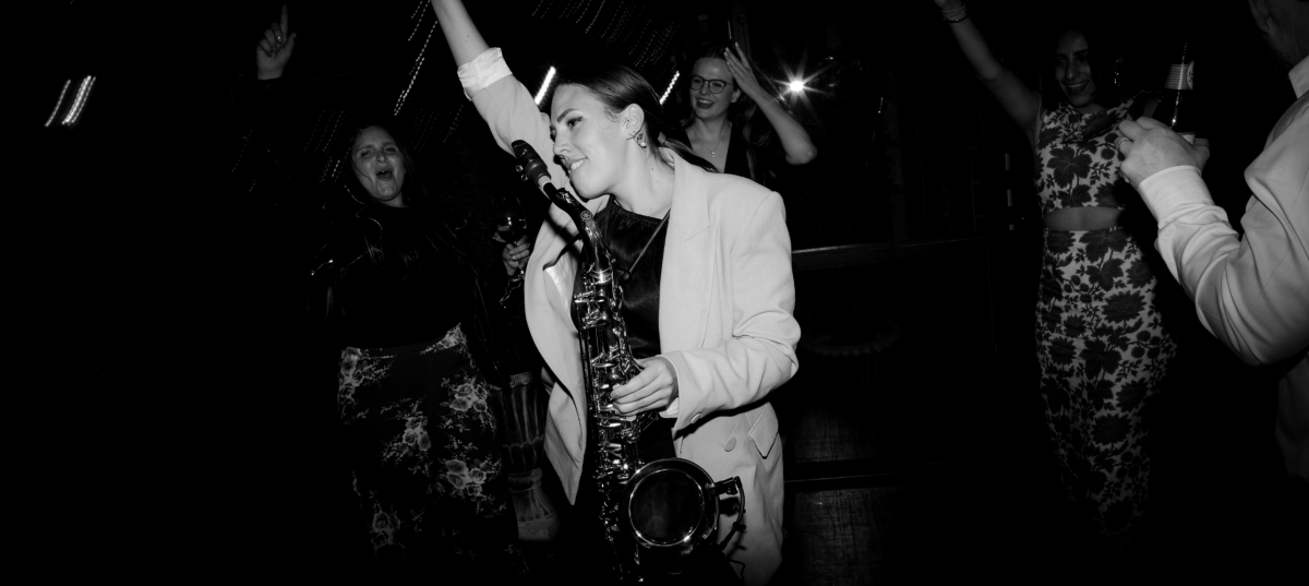 Female Sax player dancing in crowd Black and White photo