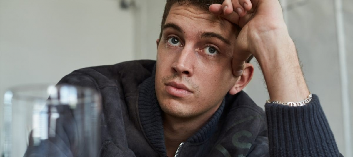 A male artist in jumper leaning on coffee table