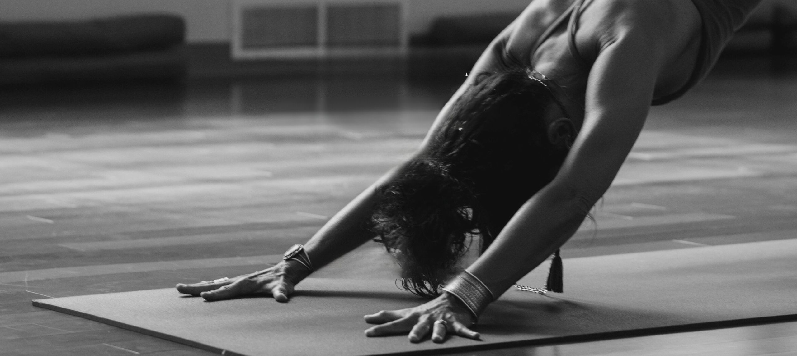 Black and white image of women in downward dog yoga position