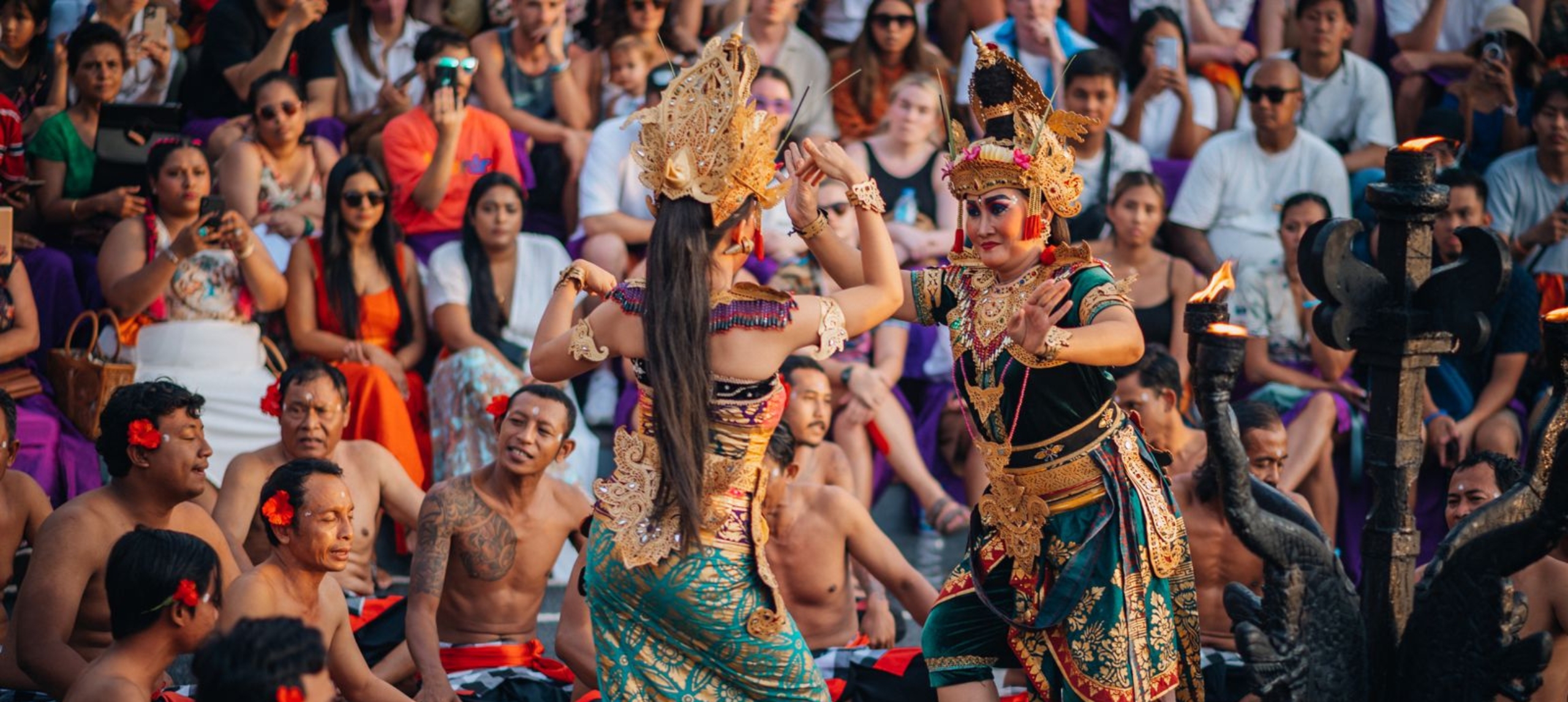 Traditional Indonesian performance - two women dancing and crowd in the background